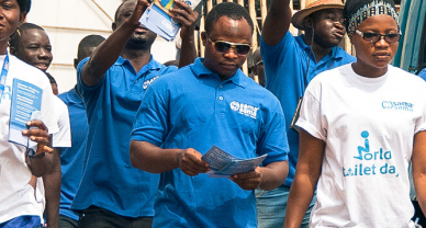 Un groupe de personnes représentant l'entreprise de latrines Sama Sama au Ghana défilent.