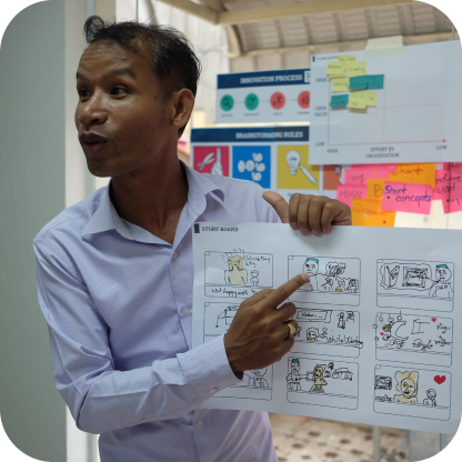 A man holding up a storyboard on a sheet of paper.